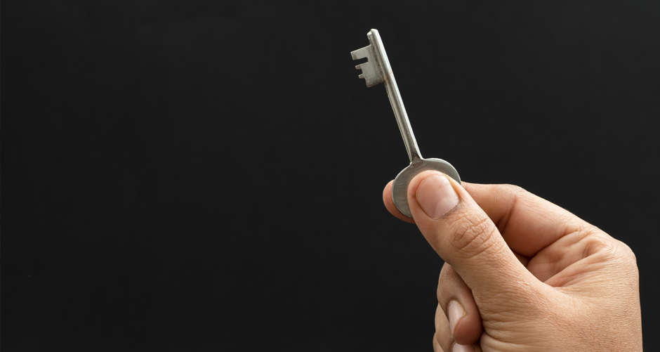 Image shows a man holding a key